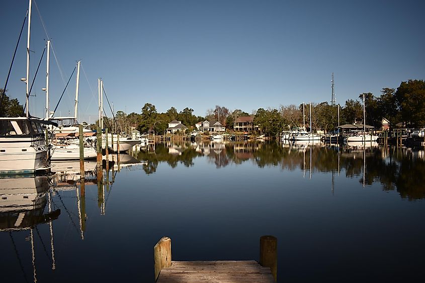 Bluewater Bay Marina in Niceville, Florida, with boats docked along the pier and clear blue skies overhead.