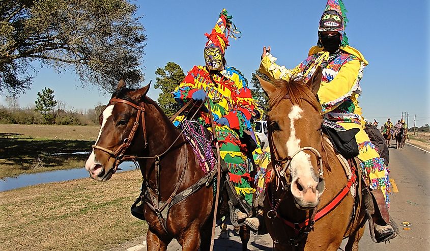 Two Cajun Mardi Gras horseback riders dressed in colorful outfits in Eunice, Louisiana,