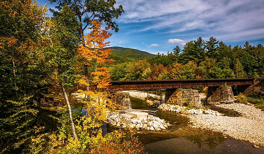 Train bridge over a river and autumn color near Bethel, Maine