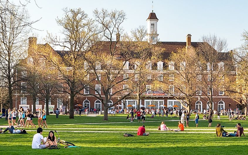 Students walk and sit outside on Quad lawn of University of Illinois college campus in Urbana Champaign