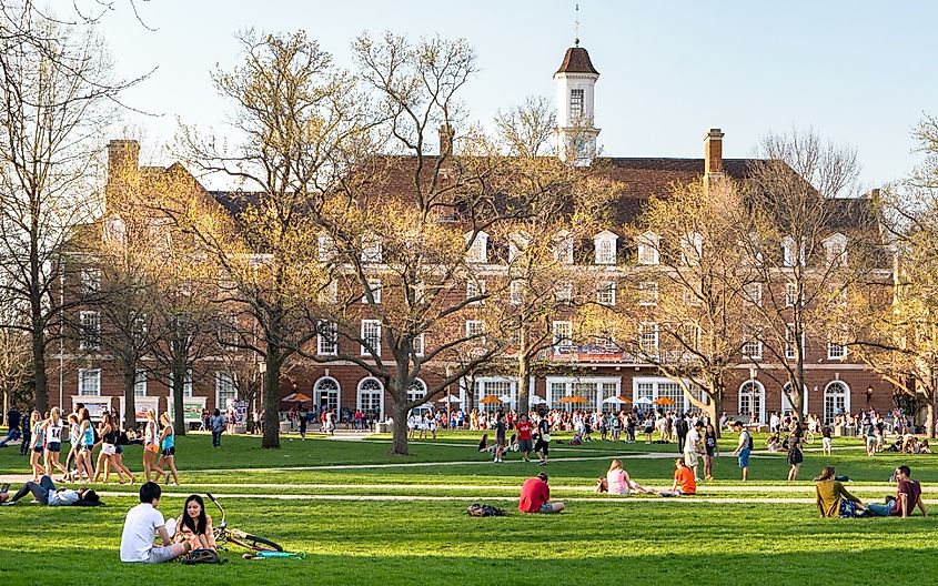 Students walk and sit outside on Quad lawn of University of Illinois college campus in Urbana Champaign