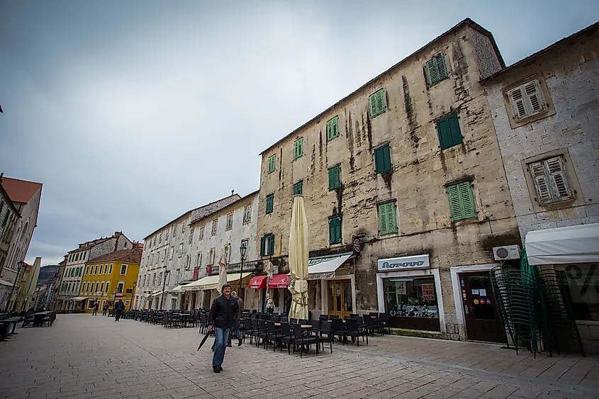 The main square in Sinj with traditional buildings, cafes, and a pedestrian area.