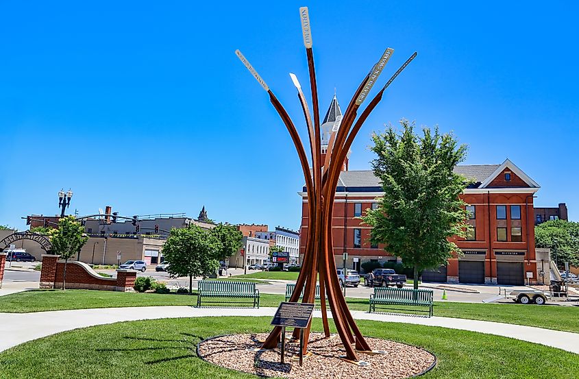 Bowling Green, Ohio USA - June 23, 2022: The "Our Ties That Bind" sculpture at Wooster Green which has eight pillars branching out with laser cut words on stainless steel plates that light up at night