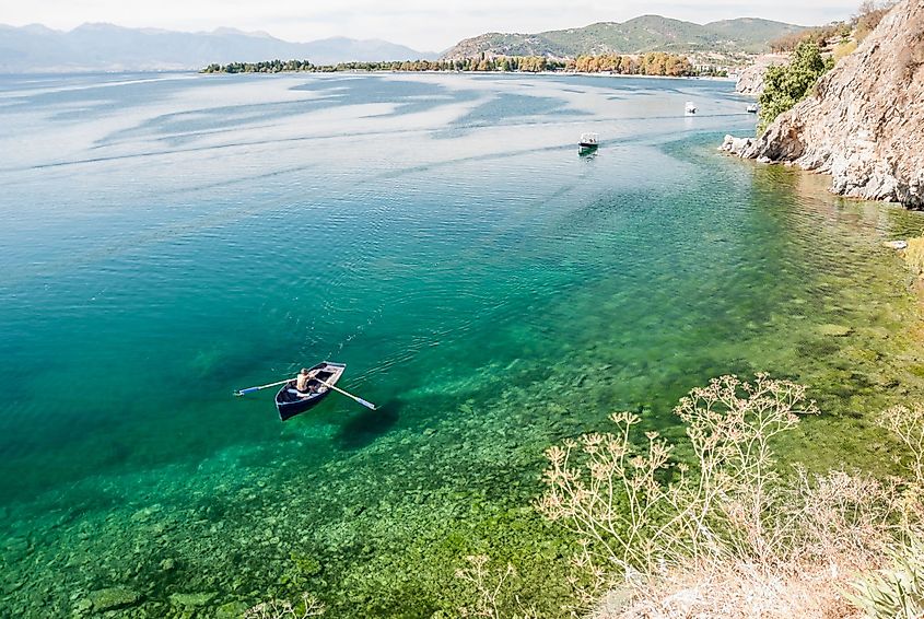 A man paddling a boat in the calm waters of Lake Ohrid, Macedonia