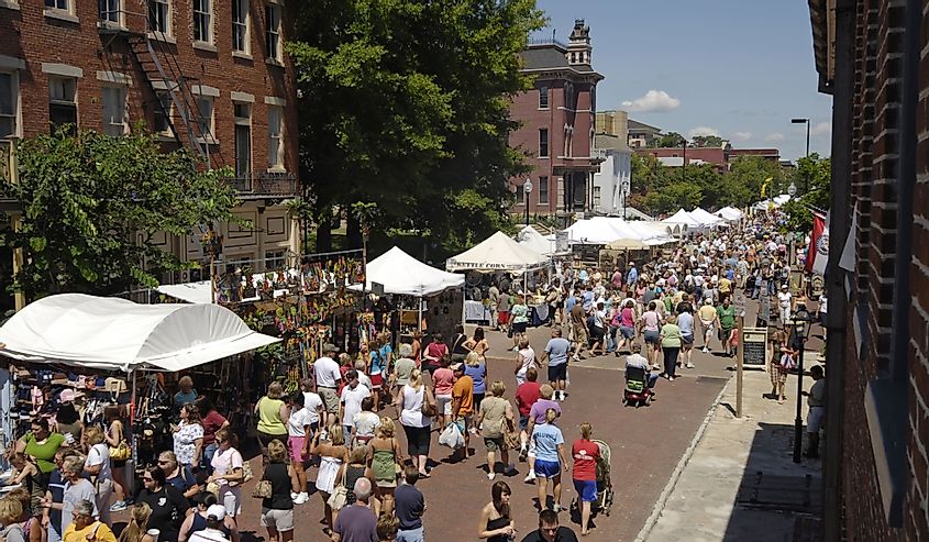 A crowd of people walking and exploring at a summer street festival in St. Charles, Missouri