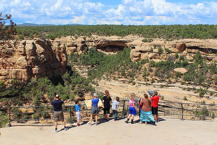 People admiring the cliff homes in the Mesa Verde National Park near Cortez, Colorado.