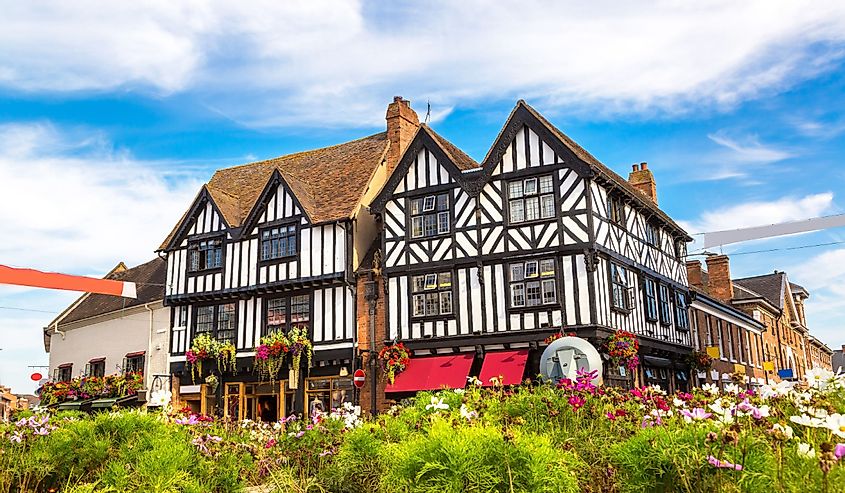 Фахверковый дом в Стратфорде-на-Эйвоне, Англия, Великобритания с цветами и зеленью на переднем плане