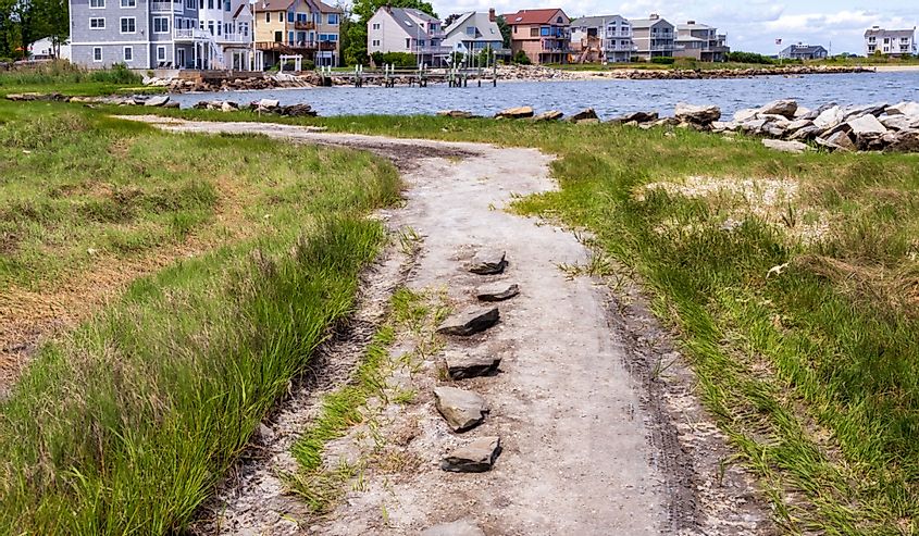 Coastal gravel road with the small seaside neighborhood on the background in East Greenwich, Rhode Island
