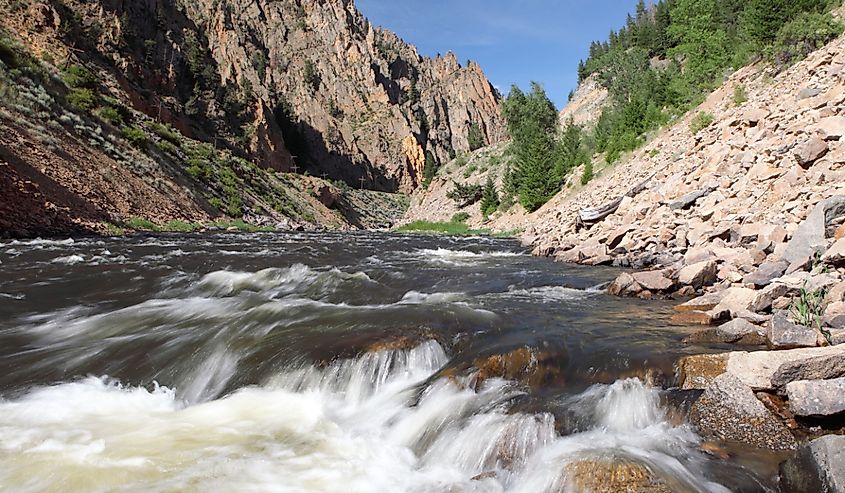 Colorado River, Byers Canyon, Colorado surrounded by mountains and evergreens.