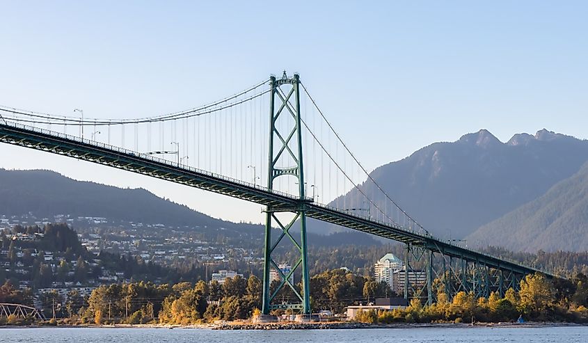 Famous Lions Gate Bridge from Stanley Park in a modern city. Downtown Vancouver, British Columbia.