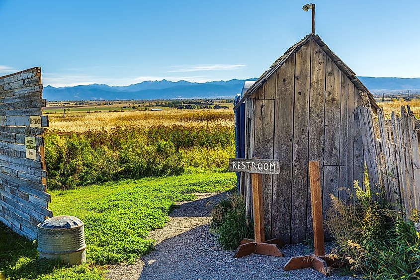An old rustic outhouse sits in a field in Belgrade, Montana