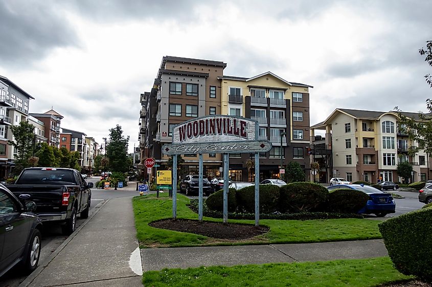 Street view of the Woodinville city center sign outside of a major shopping area on a cloudy, overcast day