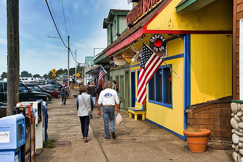 People walking on a sidewalk in front of shops in downtown Depoe Bay Oregon, via Bob Pool / Shutterstock.com