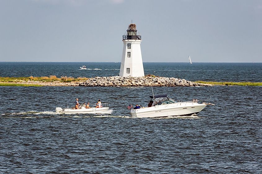 Fayerweather Lighthouse with two power boats passing by in Bridgeport, Connecticut.