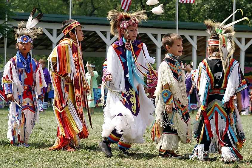Teenagers participating in the Meskwaki Powwow in Tama, Iowa, wearing traditional regalia during the annual cultural event