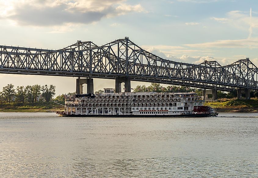 Paddle steamer river cruise boat "American Queen" departing under the interstate bridge from Natchez, Mississippi.