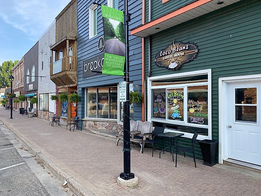 A series of shops with colorful sidings line a small-town main street. 