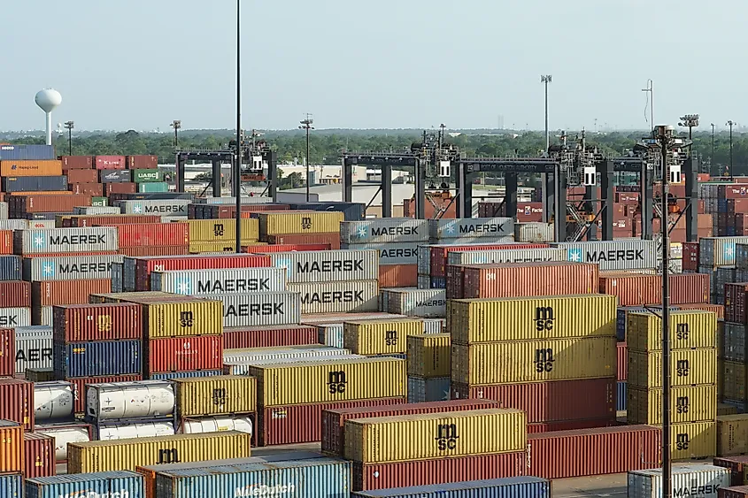 Stowed colorful containers from various shipper situated in cargo terminal of Houston port ready for loading on vessels and transport to other countries. Via Shutterstock / Luciavonu