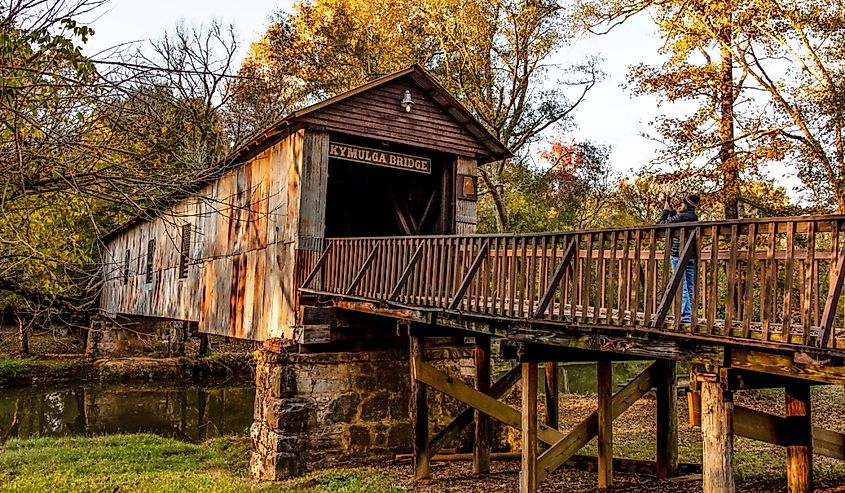 A tourist takes a photo of Kymulga Covered Bridge,