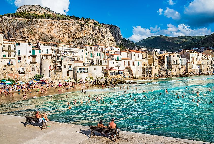 People enjoying a sunny day at the beach in Cefalu.