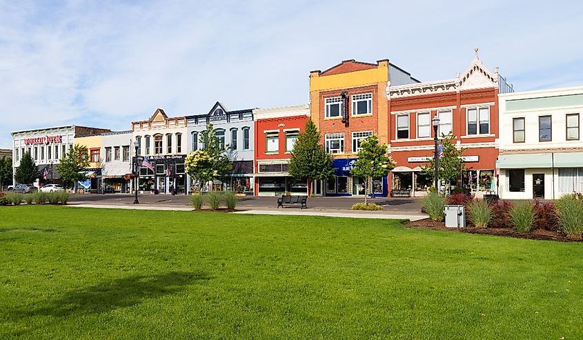 Colorful shops in downtown Dallas Oregon on Kings Valley highway with grass