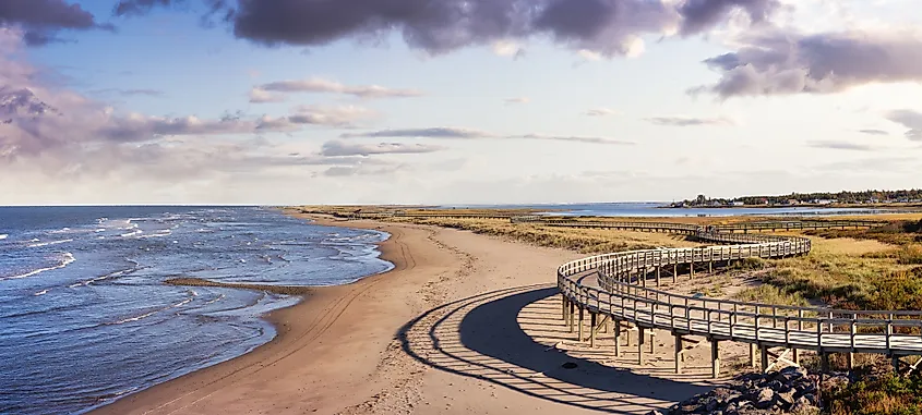 Panoramic view of a beautiful sandy beach on the Atlantic Ocean Coast. Sunset Sky Art Render. Taken in La Dune de Bouctouche, New Brunswick, Canada.