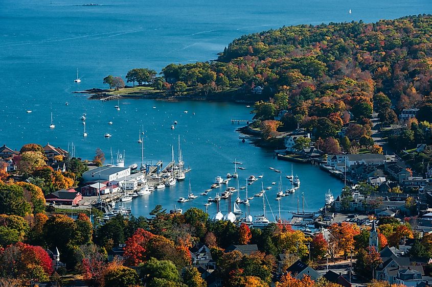 Aerial view of Camden Harbor, Maine, showcasing vibrant fall foliage.