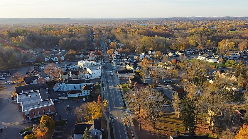 Aerial view Penfield town with local business, residential houses, churches along Five Mile Line Street, via 
