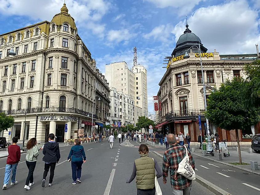 A popular pedestrian street cuts through the large historic structures of central Bucharest.