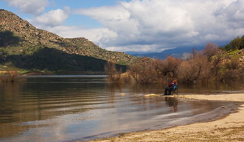 Woman is Fishing on the Lake Kaweah. Scenic of Lake Kaweah with Mountains in the Background. Three Rivers, California