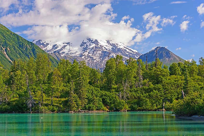 Glaciated Mount Redoubt Volcano looming in the distance over Crescent Lake in Lake Clark National Park, Alaska