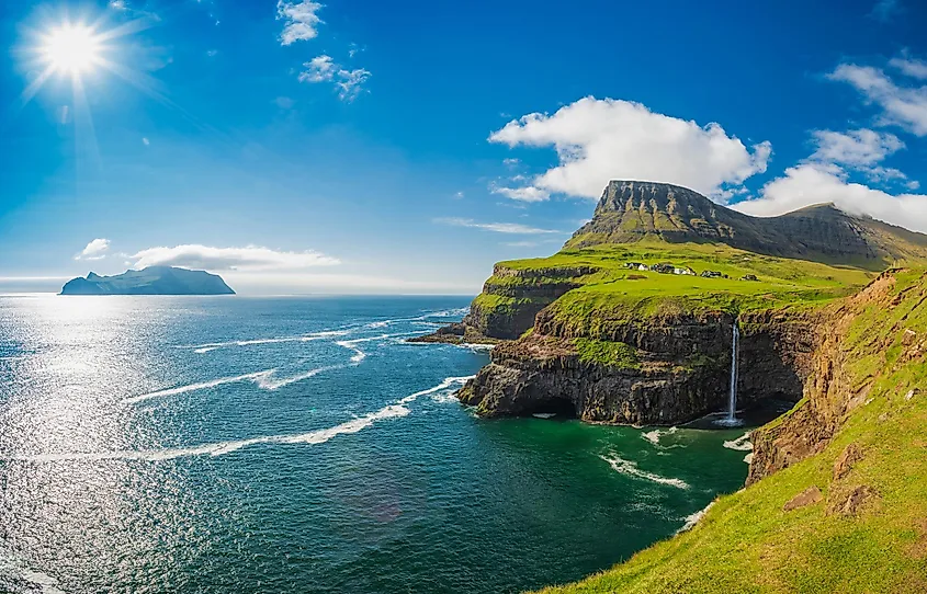 Coastal cliffs and green slopes on Vagar in the Faroe Islands.