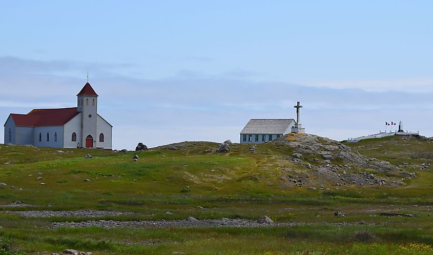 Lush green island landscape with church and monument on Ile aux Marin St Pierre and Miquelon