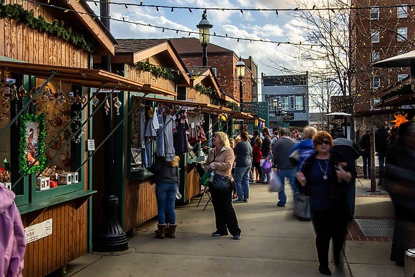 Shoppers moving between vendor cottages at the Belleville Christkindlmarkt in Illinois.