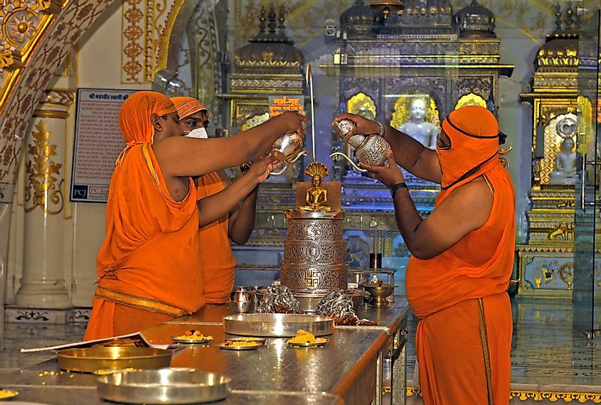 Jain devotees pour water on the idol of Lord Parshwanath