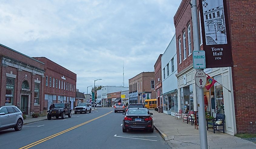 Early evening street scene down Market street lined with red brick buildings under blanket of layered stratocumulus cloud cover, Onancock, Virginia