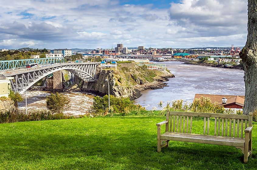 Saint John, New Brunswick, from the Reversing Falls Park with an Empty Wooden Bench in Foreground.