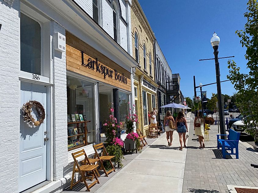Women walking past a small town book shop on a sunny day.