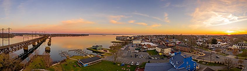 An aerial sunset panorama of Havre De Grace in Harford County, Maryland, featuring the railroad bridge over the mouth of the Susquehanna River and the head of Chesapeake Bay.