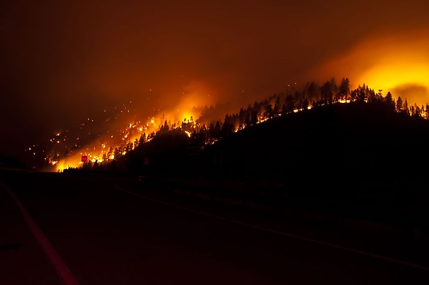 A forest fire burns at night alongside an interstate highway in western Montana