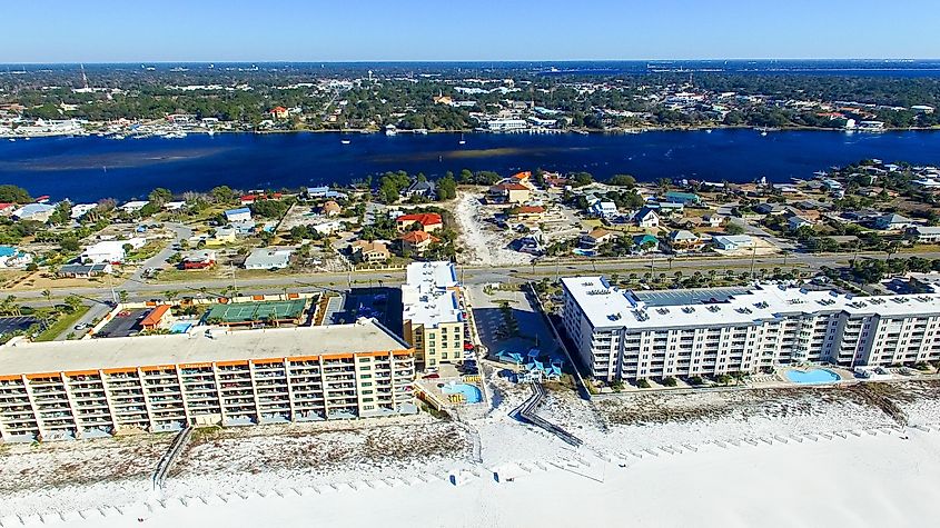 Aerial view of Fort Walton Beach, Florida: A coastal town with white sandy beaches, turquoise waters, and waterfront buildings lining the shore.