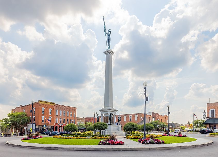 The Steuben County Soldiers Monument in downtown, with the old business district buildings, in Angola, Indiana.