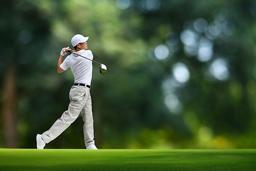 Golfer hitting a long drive down the fairway.