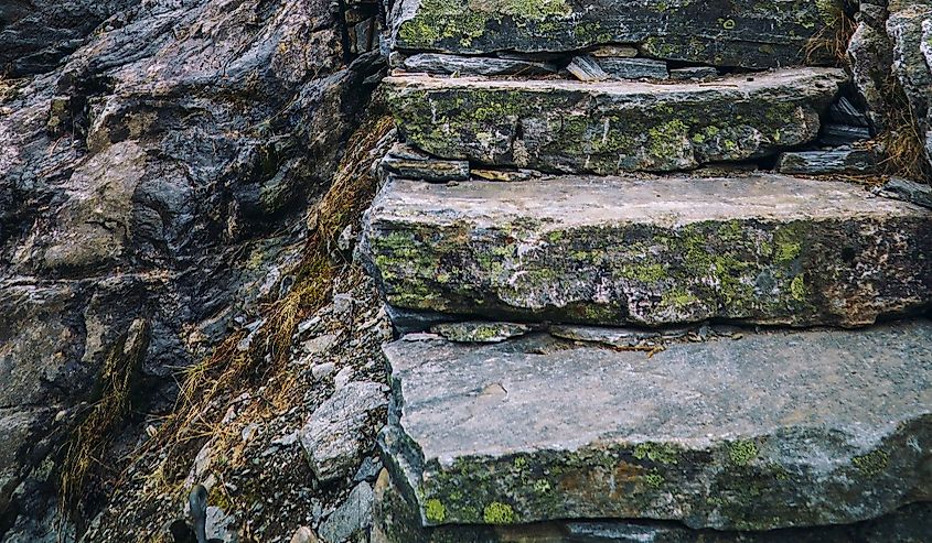 Ancient stone stairs going up on black rock, mountain stairway. Norway, Trolls road, Trollstigen.