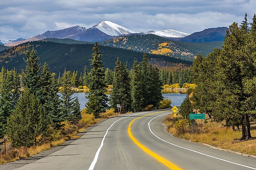 Echo Lake reflecting autumn colors with the Mt. Blue Sky Scenic Byway curving nearby and snow-capped Mt. Blue Sky rising in the background in Colorado