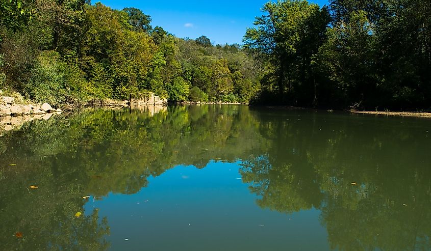A blue sky reflects in the water of the Harpeth River, Tennessee.