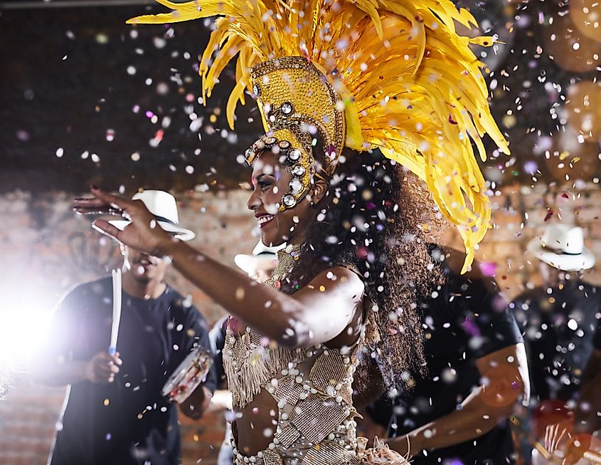 Woman, costume and party as samba performance with music, parade and energy for celebration. Dancer, happy and traditional outfit at night carnival with culture and crowd for event in rio de janeiro