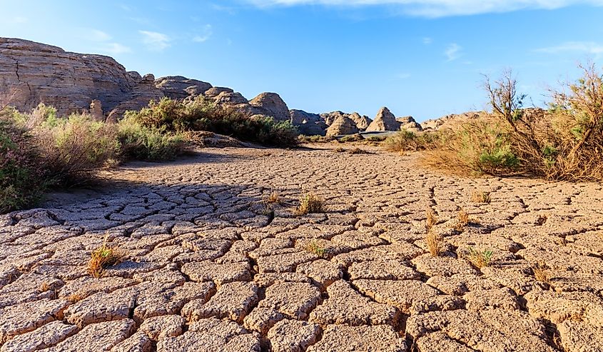 Cracked earth from a severe drought in arid desert. Famous desert gobi and Yardang landform mountain natural landscape in Xinjiang, China.