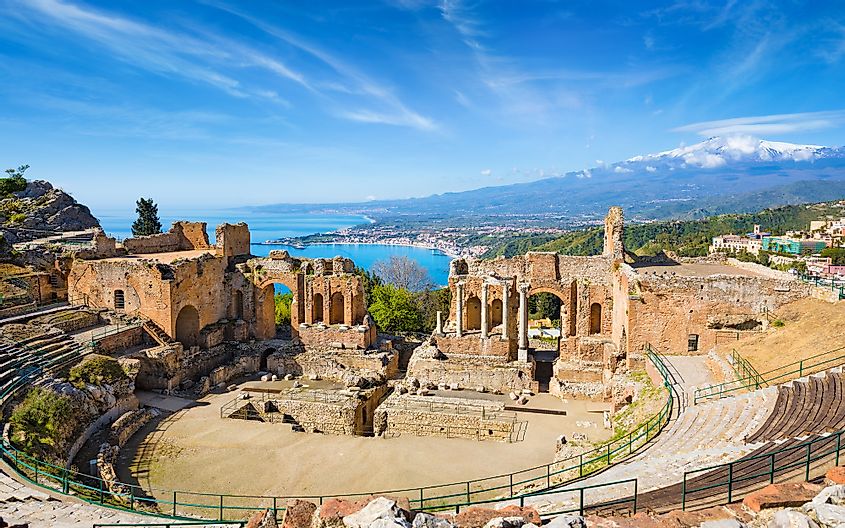 Ruins of Ancient Greek theatre in Taormina on background of Etna Volcano