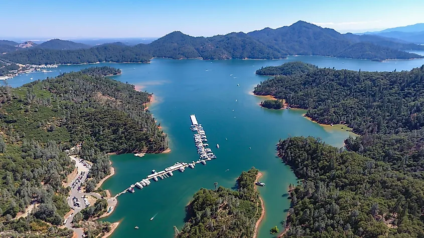 Shasta Lake in northern California with forested coves and Mount Shasta in the distance.